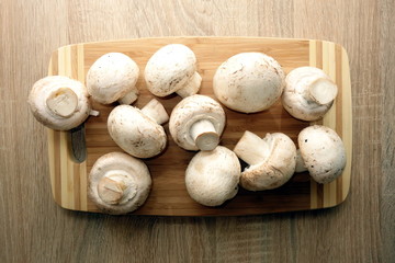 Champignon mushrooms on rustic wooden background, view from   overhead