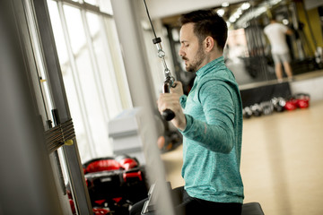 Fototapeta na wymiar Man doing excersise on a lat machine in gym