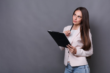 Thoughtful business woman making notes at work