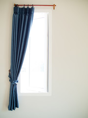 The light come in through open windows. Blue curtain are slided to edge of window. Interior design.