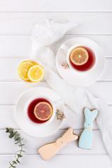 Easter bunny cookies and cup of tea. Celebration breakfast table setting. Holiday decorations.