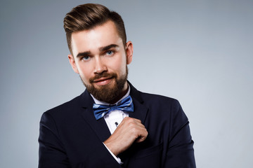 Stylish handsome man wearing a classic suit with bow-tie