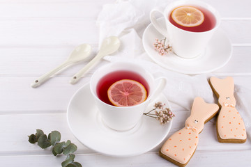 Easter bunny cookies and cup of tea. Celebration breakfast table setting. Holiday decorations.