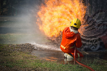 Obraz premium Firefighters training, Team practice to fighting with fire in emergency situation..Spray twist water to the flame
