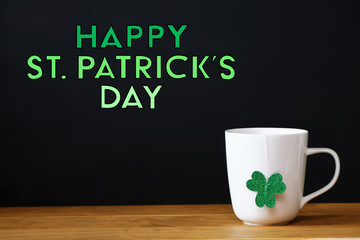 Saint Patricks Day message with a white mug on black background