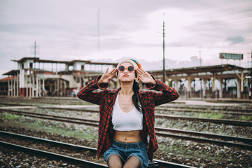 Portrait of hipster girl sit on the railway vintage style,thai woman posing for take a photo