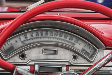 Red colored old american car details, wheel and speedometer.