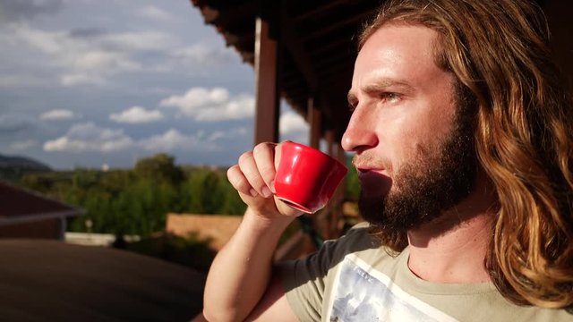 Hipster drinking coffee watching the sunset