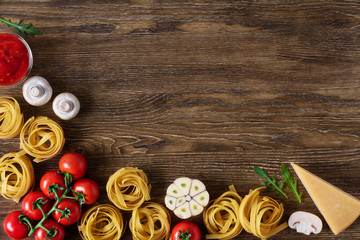 Ingredients for tagliatelle pasta on a wooden background.