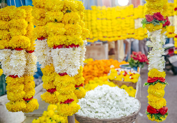 woman chooses a wreath of flowers in the market at India