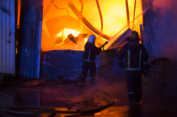 a garage on fire with flames coming thought the roof