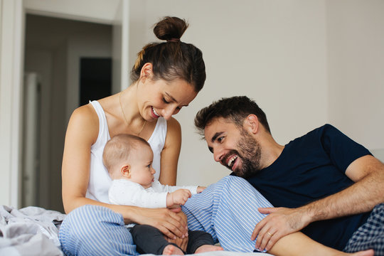 Happy family having fun with his baby boy at home.