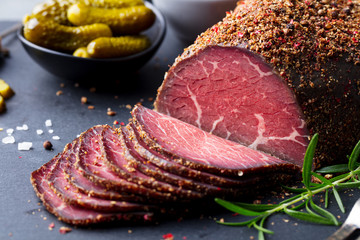 Roasted beef, pastrami on slate cutting board. Close up.