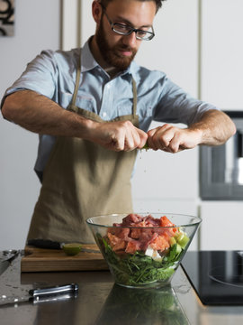 Man dressing salad with lime