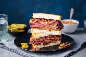 Foto op Canvas Roast beef sandwich on a plate with pickles. Copy space. © annapustynnikova