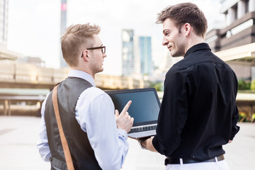 smart handsome business man meeting with his partner outdoor location with urban city background