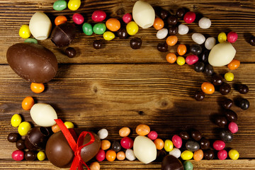 Easter composition with chocolate eggs on wooden background