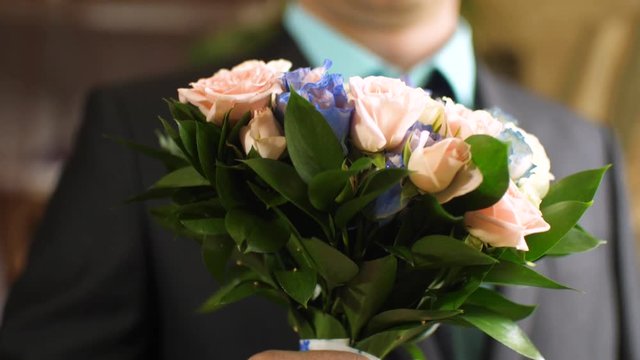 beautiful bouquet of multicolored roses in hands of men