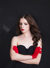 Portrait of beautiful woman in black dress with curly hair - isolated on black background