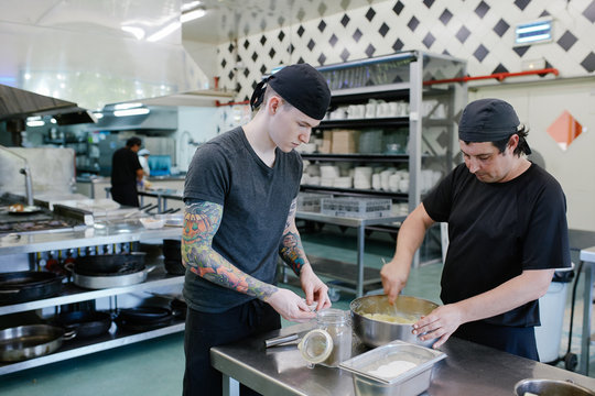 Chef and  cook apprentice working together in a catering kitchen