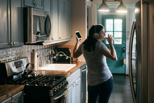 Woman listening to music in kitchen