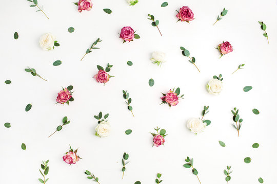 Floral pattern made of red and white rose flower buds and eucalyptus branches on white background. Fat lay, top view flowers texture.