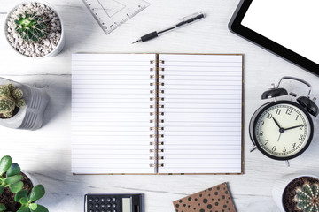 Top view on a wooden desk with a tablet, cactuses, notebook, spiral open notebook and a black clock