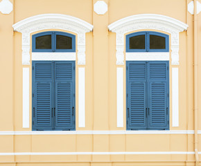 blue wood window at classic yellow building
