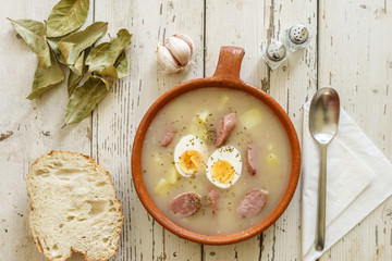 Traditional polish soup called Zurek served with bread