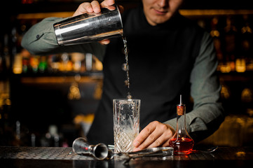 Bartender making cocktail at the bar counter