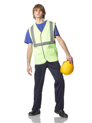 Young guy builder or trainee in work clothes with protective helmet in hands.