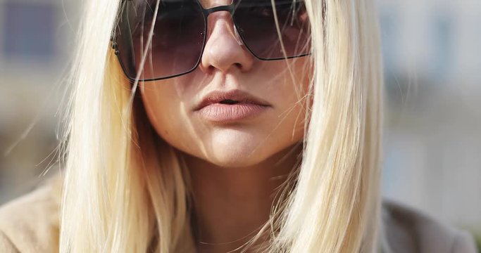 Young beautiful blonde girl in sunglasses is sad.