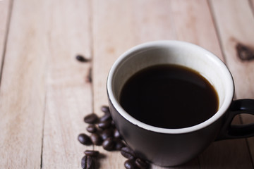 Black coffee in a glass on a wooden table