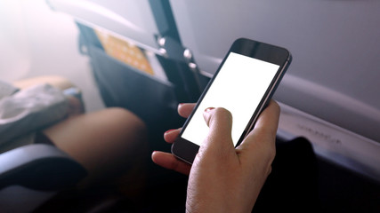 touching and slide mobile phone screen on airplane or aircraft,blank mobile phone screen mock up,selective focus