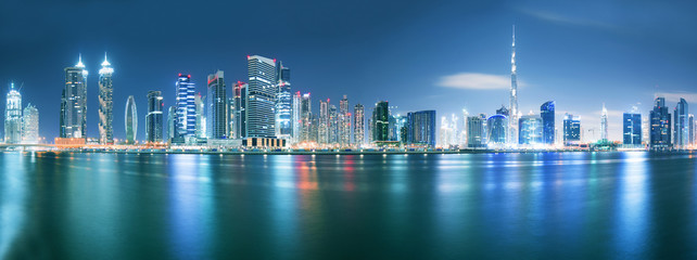 Dubai skyline after sunset with beautiful city center lights reflection and promenade around the canal, Dubai, United Arab Emirates