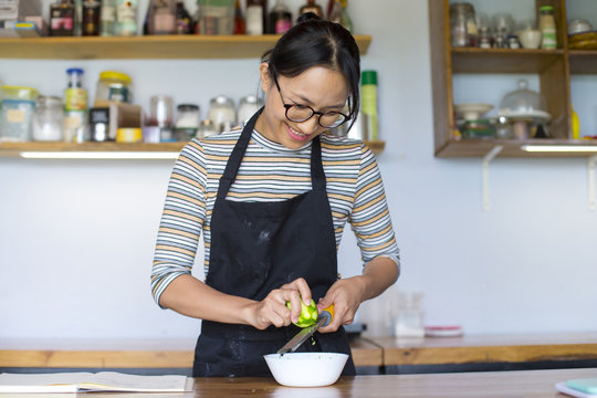 Young asian woman learning to make dessert in the kitchen