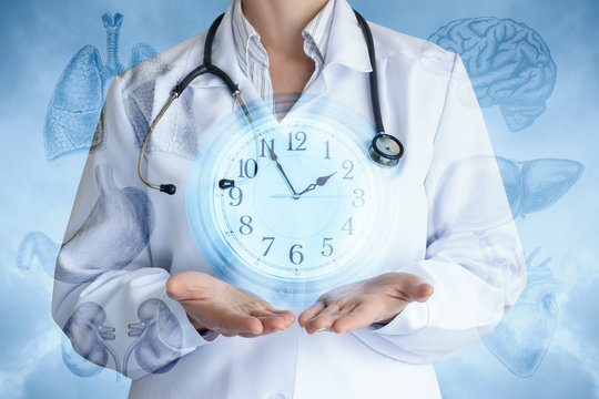 Doctor shows the clock on the background of internal organs .