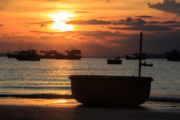 Vietnamese fishing boat silhouettes in sea at sunset