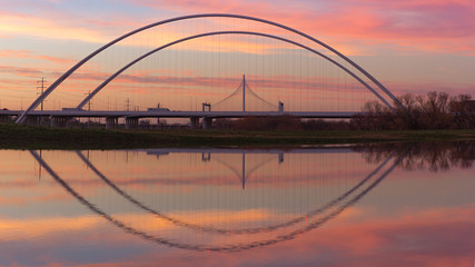 Fototapeta na wymiar Reflection of Margaret Hunt Hill Bridge and Margaret McDermott Bridge during Sunset from Trinity River, Dallas, Texas