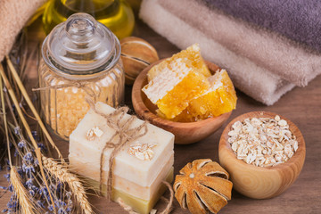 Fototapeta na wymiar Honeycomb, cosmetic oil, sea salt, oat and handmade soap with honey
