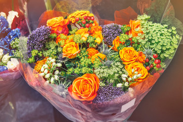 Roses of pink modern varieties with hydrangea and flowers of Alstroemeria in a bouquet in a wicker basket as a gift. Selective focus.