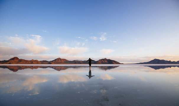 A man walking on a salt lake in the early morning
