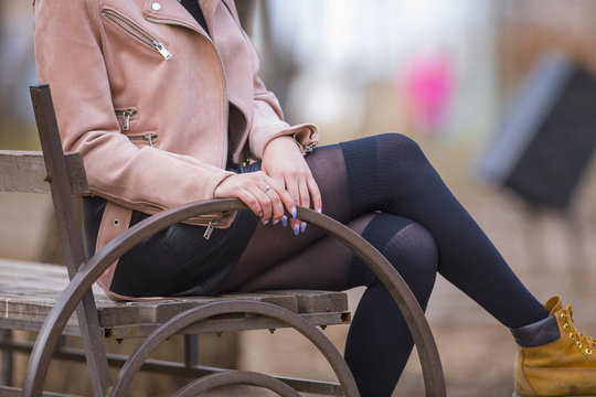 beautiful legs of a girl, a girl sits on a bench