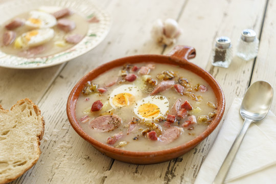 Clay pot and plate of traditional polish soup called Zurek