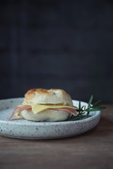 Bagel ham cheese in close up on wood background in coffee shop