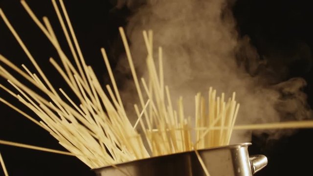Throws spaghetti in a boiling pan