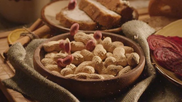 Peanuts and shells fall into a close-up plate
