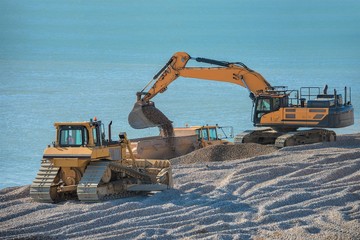 Construction Site - Engineering - Sea Defence. Large plant machinery being use to build the beach sea defence at Seaford, East Sussex, UK