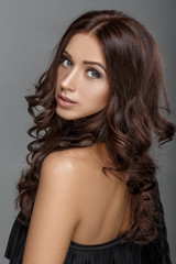 Naklejka premium brunette woman with shiny long curly hair