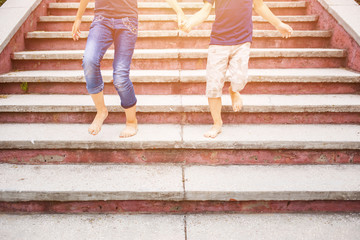 Children rushing down on stairs barefoot. Concept childhood image with copy space